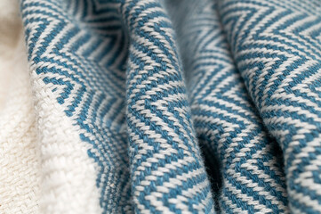Close-up of white and blue striped cotton fabric. Texture of natural, eco-friendly zigzag textile....