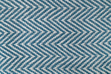 Close-up of white and blue striped cotton fabric. Texture of natural, eco-friendly zigzag textile. Material for a blanket, beach towel, or tablecloth. Abstract background