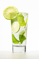 Mojito con limón y menta sobre fondo blanco en vaso alto