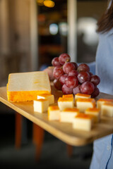 Tabla de quesos con uvas servida en ambiente de restaurante