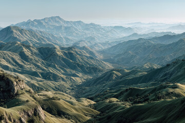 Fototapeta premium Scenic aerial view of rolling green hills and distant mountain range