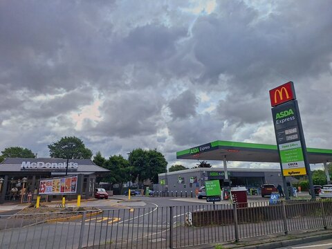 MANCHESTER, ENGLAND -JULY 16, 2025: Asda Petrol Station  and McDonald&rsquo;s fast food restaurant in Manchester, England, UK. Asda is UK's third largest chain by market share after Tesco abd Sainsbury.