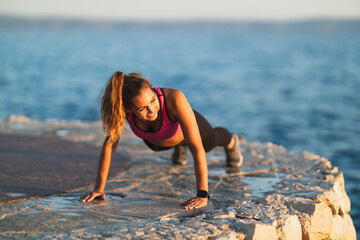 Woman Practicing Push-up During Outdoors Workout Near The Sea