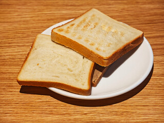 stacked pieces of toasted bread on white plate on table