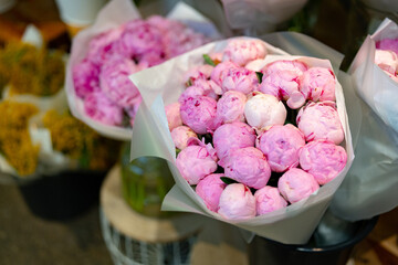 Beautiful peonies in delicate pastel shades arranged for sale at a flower market in the spring season © fotofabrika