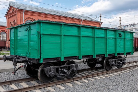 Green coal wagon on railway tracks in a station