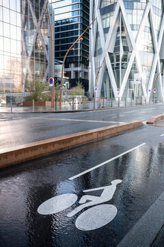 A calm Paris street reveals urban architecture shaped by modern city mobility, where empty pavement and exterior road lines define the atmosphere with subtle detail