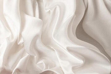 Fototapeta premium Close-up of soft, wavy lines of a satin fabric with a smooth texture in the color of the year 2026 CLOUD DANCER