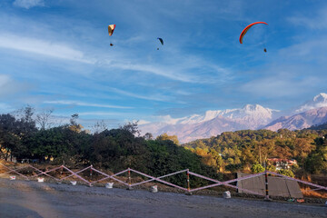 Paragliding over the clouds sunset view at Bir Billing Himachal Pradesh India. Clouds in the sky, Dhauladhar snow peaks.