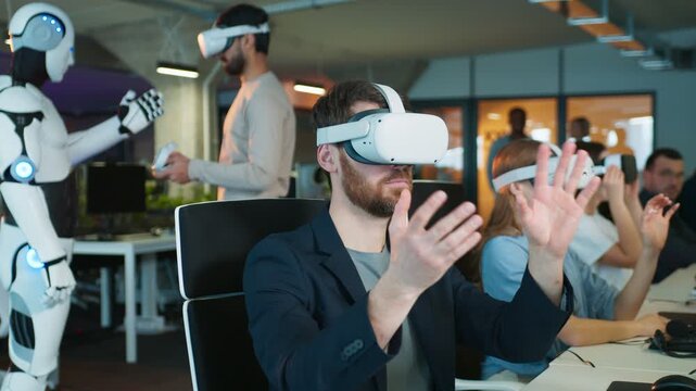Male interacting with virtual object in VR headset. Woman beside him engaging in simulation. Humanoid robot observing male in background. Group in office supporting immersive digital tasks.