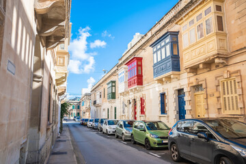 Cozy street and traditional colorful wooden balconies in Sliema, Malta