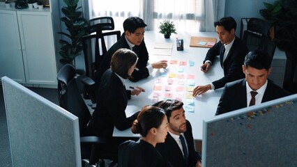 Top view of marketing team brainstorm idea while executive manager write whiteboard and plan financial strategy at meeting room. Group of diverse people working together to solve problem. Directorate.