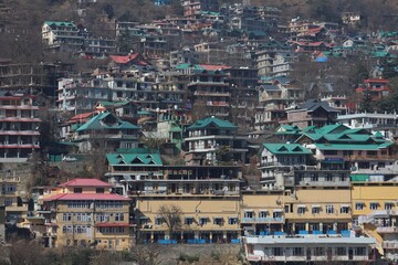 Colorful Rooftops Over Shimla SlopesPanoramic view of hillside structures with green, red, and yellow rooftops in Shimla, showing the charm of a mountain city.