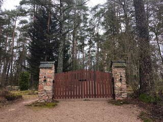 wooden gate, entrance to the cemetery. Stone gateposts. Jaunzemju Cemetery, Latvia, Zemgale