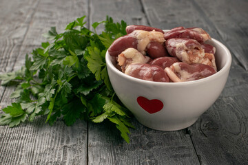 Fresh Chicken Hearts in Bowl with Parsley on Rustic Wood Table - Culinary and Food Concepts