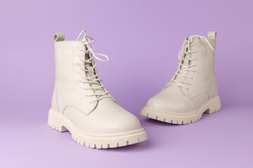 Stylish Off-White Leather Boots on Purple Background Showcasing Modern Fashion Trends