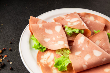Mortadella sausage slices meat food tasty snack fresh delicious gourmet food background on the table rustic food top view copy space