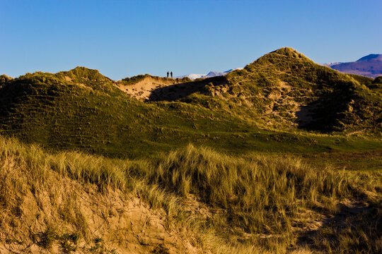 Wintertime scene from Newborough Warren sand dunes featuring the snow-capped peaks of the Snowdonia Mountains, Area of Outstanding Natural Beauty, Anglesey, Gwynedd
