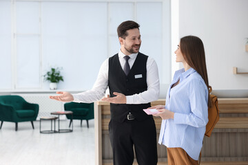 Receptionist welcoming guest at reception in hotel