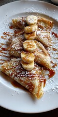 Delicious Bananas Foster Crepe: A Decadent Dessert Topped with Sweetened Banana Slices and Light Dusting of Powdered Sugar