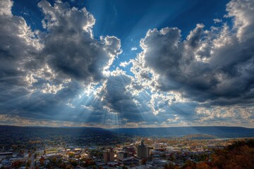 Stunning Autumn Vista over Altoona: Dramatic Skies and Sun Rays Illuminate the Cityscape Against a Mountain Ridge