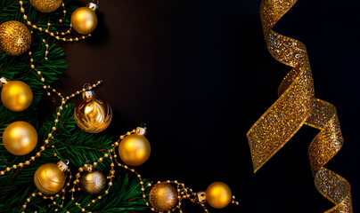 Christmas minimalistic and simple composition in mat black and gold color. Christmas decor, gold decorations on black background. Flat lay, top view with copy space. Autumn winter background.