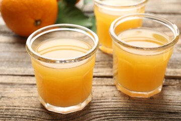 Fresh orange juice and fruits on wooden table, closeup