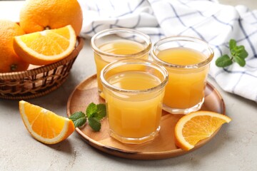 Fresh orange juice, mint and fruits on light table, closeup