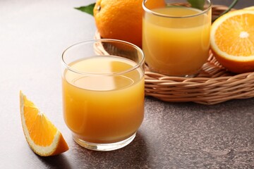 Fresh orange juice and fruits on grey table, closeup