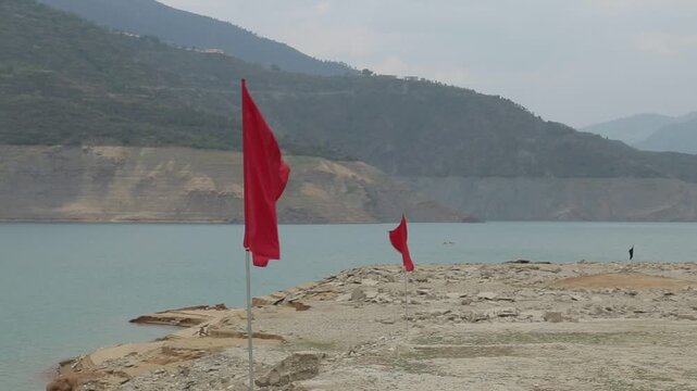 Red flags near Tehri Dam lake shoreline in Uttarakhand India

