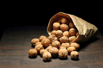 Walnuts on an old rustic table. Walnuts in a paper bag.