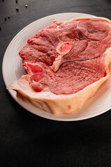 Bone-in ham steak, raw pork ham on the bone tasty snack fresh gourmet food background on the table  rustic food top view copy space