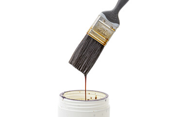 A black bristle paint brush is placed over a can of white lacquer with lacquer dripping from the brush back into the can