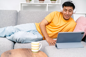 Young man relaxing watching media on tablet