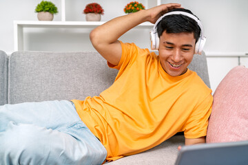 Young man relaxing on sofa enjoying remote work
