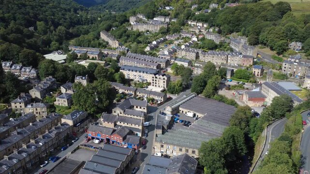 aerial drone view of streets of houses in hebden bridge in summer surrounded by trees