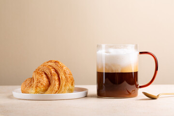 Breakfast with Croissant and mug of cappuccino coffee  with milk.