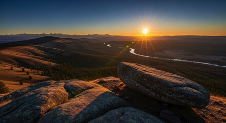 Brilliant sunburst illuminates a vast wilderness landscape at sunrise