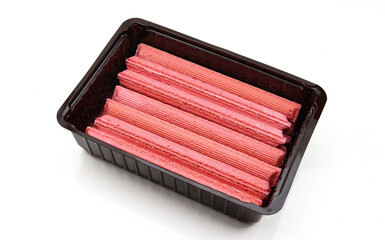 Set of red wafer sticks filled with cream inside of black plastic box isolated on white background
