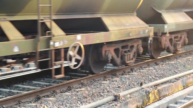 Close-up of freight train wheels moving along railway tracks in India. The scene captures industrial motion, heavy transport mechanics, and rail logistics.
