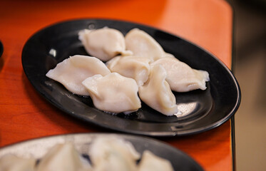 Fresh Steamed Dumplings on Black Plates in Restaurant