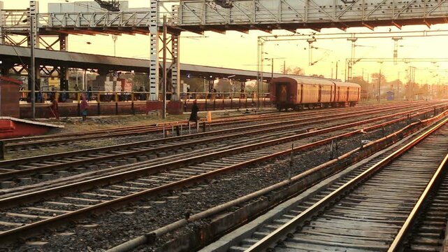 Railway tracks stretch into the distance at an Indian railway station during sunset. The scene reflects transport infrastructure, travel routes, and calm evening atmosphere in India.
