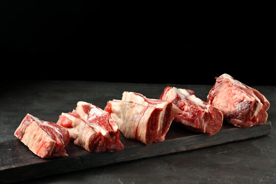 fresh beff ribs on a board.black background