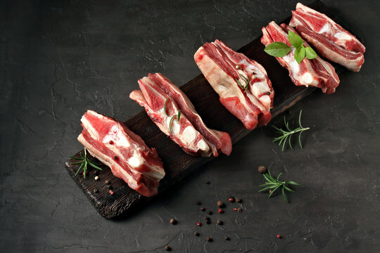 fresh beff ribs on a board.black background