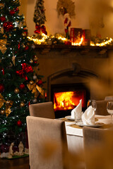 Cozy Christmas dining room with a decorated tree, warm fireplace, festive lights, and an elegant table setting ready for a holiday celebration.