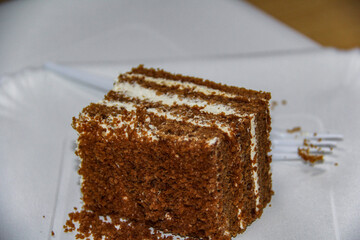 pieces of chocolate cake with white cream lying on plates, birthday, disposable tableware, forks, dessert,