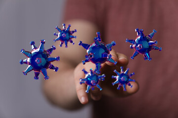 3D rendering of coronavirus cells floating near hand. Concept of virus, disease, medical research, and health