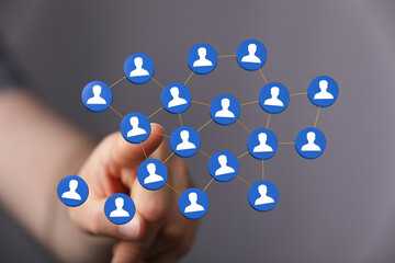 Visualize connection, teamwork, or social interaction, hand pointing to human icons in a network grid, modern c