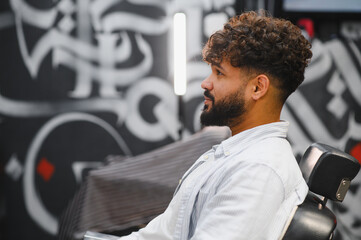 Young man getting a modern haircut in barbershop