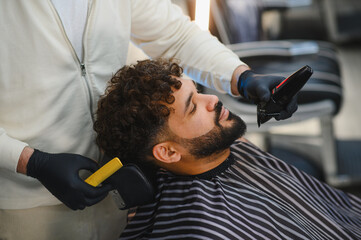 Barber giving haircut and beard trim to client